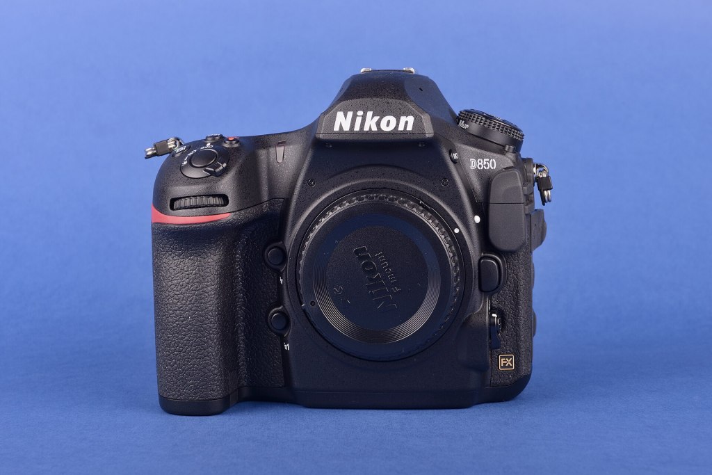 Front view of a Nikon D850 camera against a blue background.